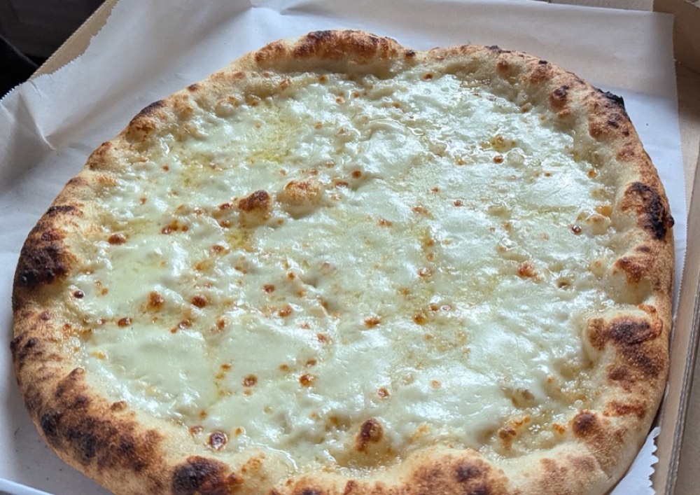 The white pie: no tomato, a pale cream and mozzarella surface flecked with pepper.