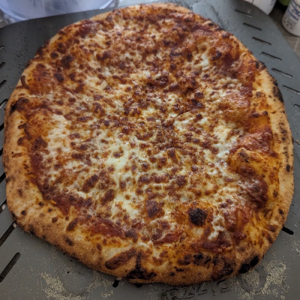 A cheese pie straight off the stone, the mozzarella browned in patches across the top.